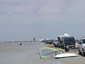Smaller RVs and vehicles parked all along the shoreline