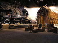 Early steam engine about to enter an early version of the snowsheds along the route through the Sierra mountains.